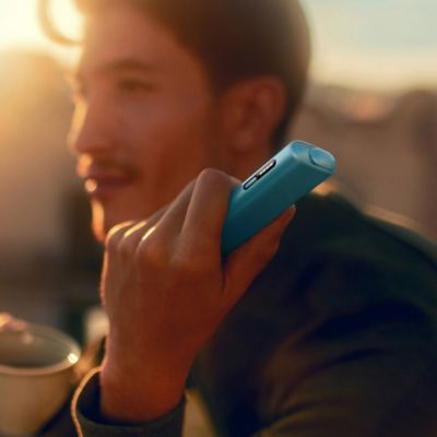 Seseorang yang memegang Pengecas Poket IQOS ILUMA PRIME Jade Green.