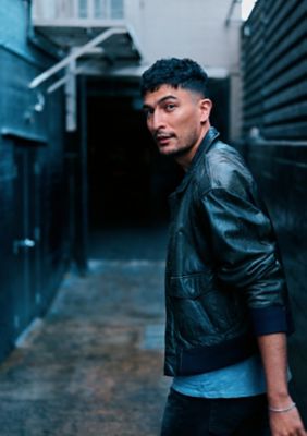 Hombre sentado en un concierto mirando al guitarrista