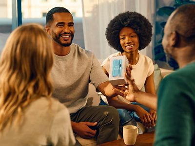 Muž ukazující balení IQOS ILUMA i skupině lidí