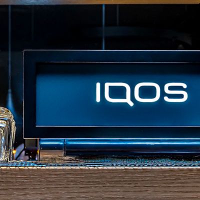 Držák s logem IQOS na pultě v IQOS Lounge