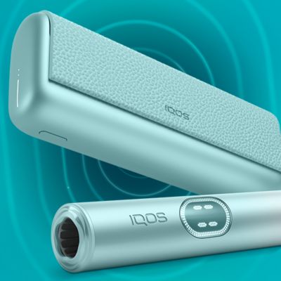 Modré zařízení IQOS ILUMA i PRIME na tyrkysovém pozadí