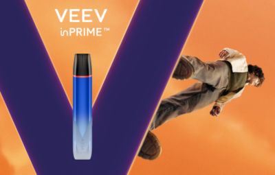 Zařízení VEEV inPRIME v písmenu V, vedle stojící člověk na oranžovém pozadí