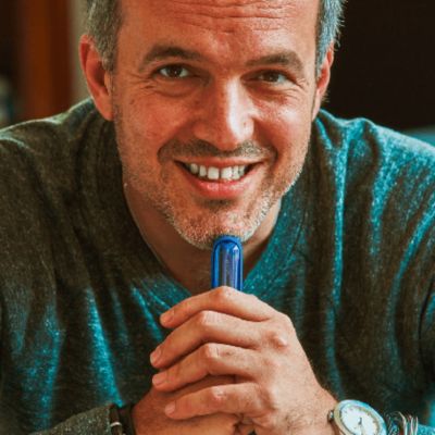 Můž se usmívá a drží IQOS ILUMA v ruce