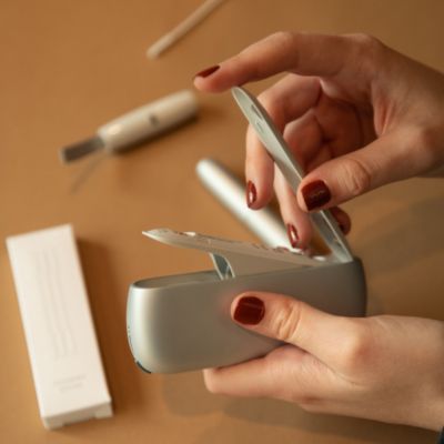 Eine Person hält ein IQOS Orginal Duo in der Hand