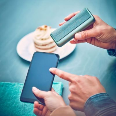 A friend explains to a man that he can access live chat support for real-time assistance from IQOS experts.