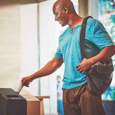 A man putting an old device into a collection box.