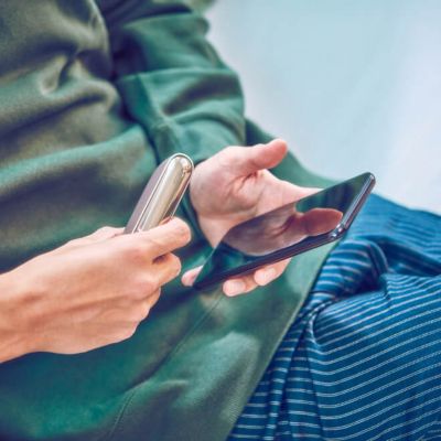 Persona registrando su dispositivo IQOS en línea a través de un celular inteligente.