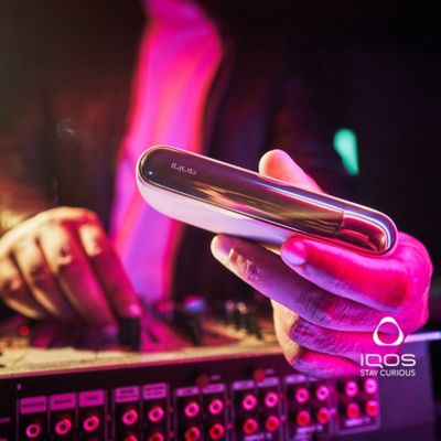 A DJ holding an IQOS ILUMA Charger