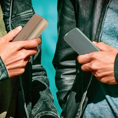 A person holding a pack of TEREA sticks while holding an IQOS ILUMA device.