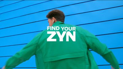 Tancující muž v zelené košili a anglický nápis Najdi svůj ZYN