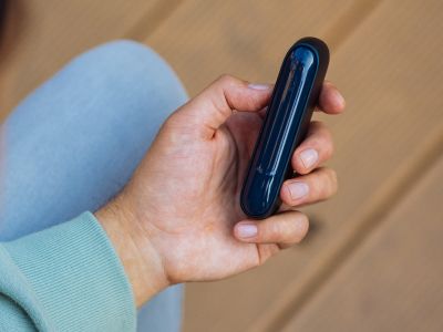 Eine Hand hält ein schwarzes IQOS ORIGINALS DUO Gerät.