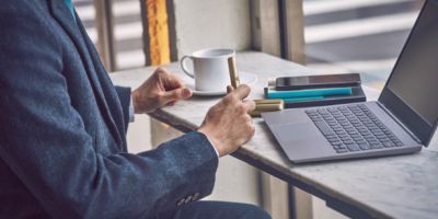 A man sitting on a couch looking at a laptop.