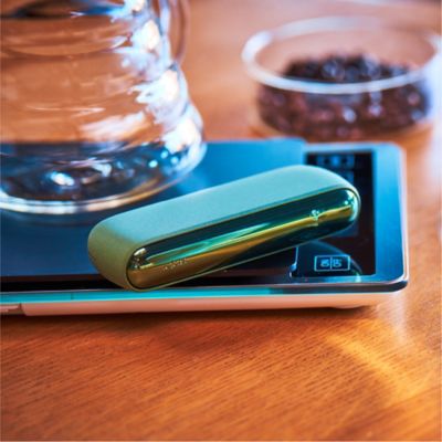 A person holding an IQOS device