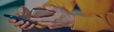 Young man with a mobile and IQOS 3 in his hands