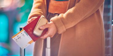 Eine Person hält ihren Reisepass und ihr IQS Gerät in den Händen