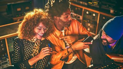 Friends at a housewarming party, one holding an IQOS device.