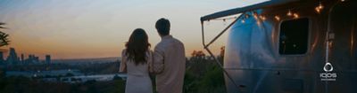 A couple camping together and looking over the horizon