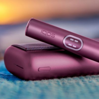 An IQOS ILUMA PRIME device, with Pocket Charger and Holder.