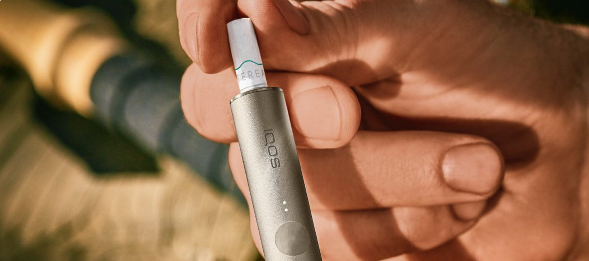 A close-up of a person slotting a new TEREA stick into their IQOS ILUMA device