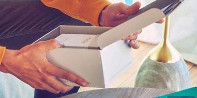 Die Hände eines Mannes, der ein IQOS Paket öffnet.