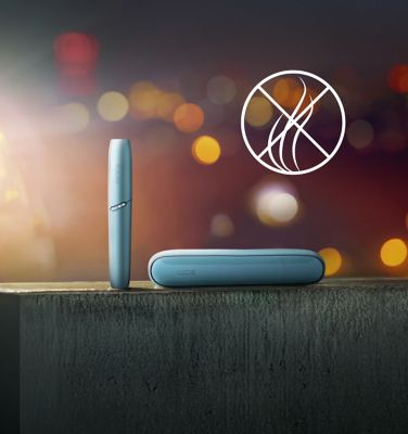 Ein blaues IQOS ORIGINALS DUO Gerät befindet sich auf einer Betonoberfläche vor einem Symbol mit durchgestrichenem Rauch.