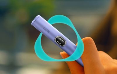 Eine Hand hält ein IQOS ILUMA i in Violet.