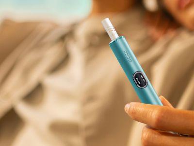 Hand holding an IQOS ILUMA i device