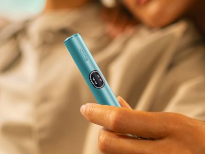 Рука держит устройство IQOS ILUMA i