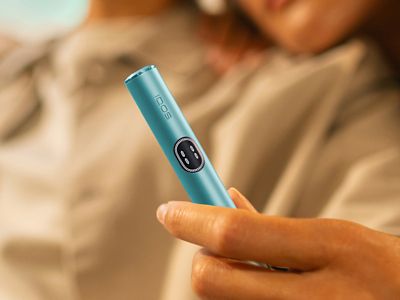 Tangan memegang IQOS ILUMA i Breeze Blue
