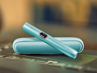 Modro držalo naprave IQOS ILUMA i, naprava na žepnem polnilniku.