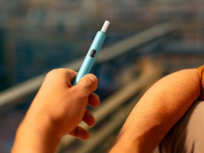 Hand holding an IQOS ILUMA i device