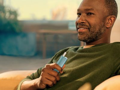 Man holding IQOS ILUMA I ONE Device with Tobacco stick inserted