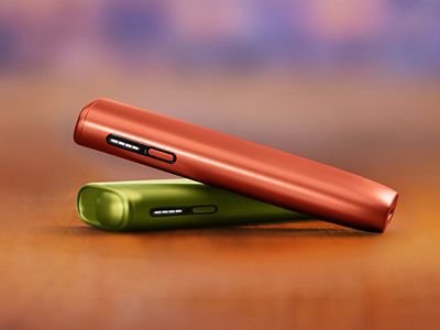 Rdeča IQOS ILUMA i ONE na zeleni IQOS ILUMA in ONE.