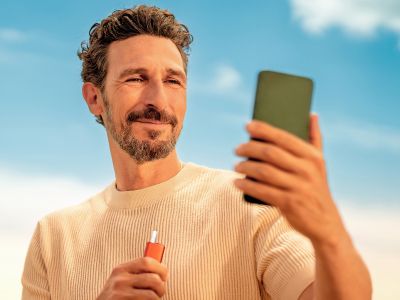 Man holding IQOS ILUMA I ONE Device with Tobacco stick inserted