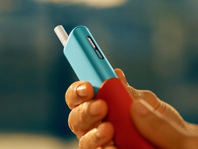 يد تحمل جهاز IQOS ILUMA i ONE أثناء إخراجه من غلافه