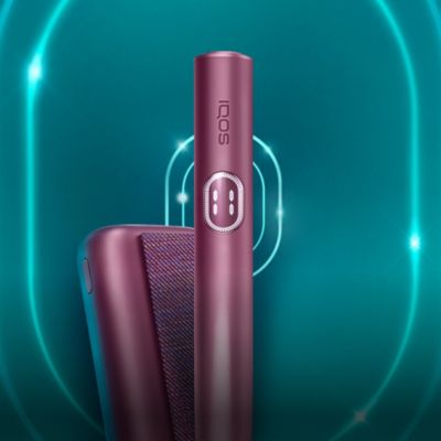 Устройство IQOS ILUMA i PRIME цвета гранатовый красный и зарядное устройство внутри логотипа IQOS