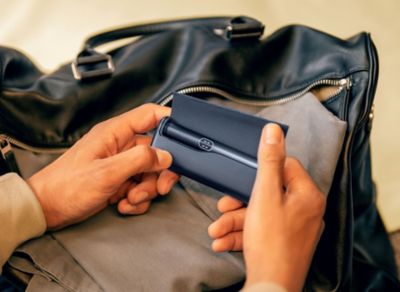 IQOS ILUMA i PRIME in der Farbe Midnight Black vor geöffneter Tasche.