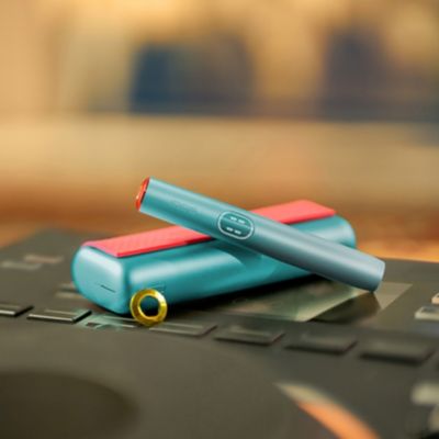 Modro držalo naprave IQOS ILUMA i PRIME na žepnem polnilniku z etuijem in obročki