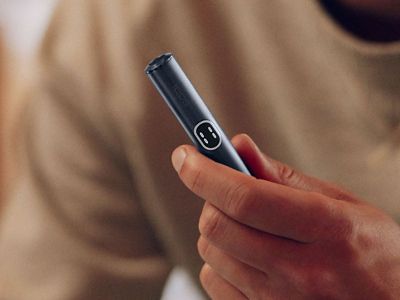 Eine Hand hält den Holder eines IQOS ILUMA i PRIME in Midnight Black.