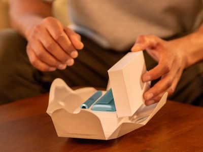 Руки распаковывают устройство IQOS ILUMA i PRIME