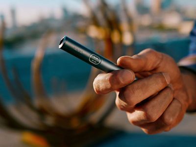 Eine Hand hält den Holder eines IQOS ILUMA i PRIME in Midnight Black.