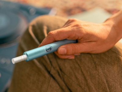Hand holding an IQOS ILUMA i PRIME device