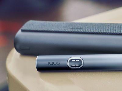 IQOS ILUMA i PRIME in Midnight Black auf einem Tisch liegend.