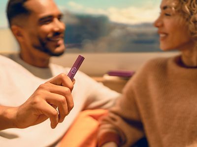 A MAN HOLDING IQOS ILUMA I HOLDER DIGITAL VIOLET