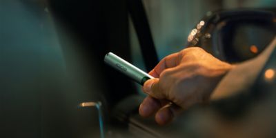 Una persona sosteniendo una caja cerrada de un dispositivo IQOS.