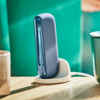 An IQOS ILUMA Pocket Charger in a charging station.