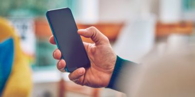 Un teléfono celular en la mano de una persona.