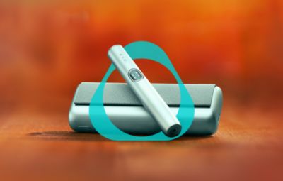 Držalo in žepni polnilnik naprave IQOS ILUMA i PRIME v svetlomodri barvi Breeze Blue z logotipom IQOS.