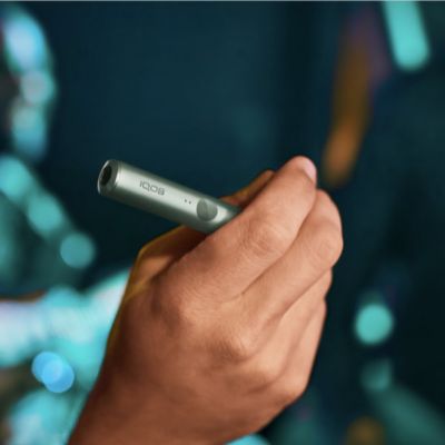 Manos sosteniendo un IQOS ILUMA PRIME verde