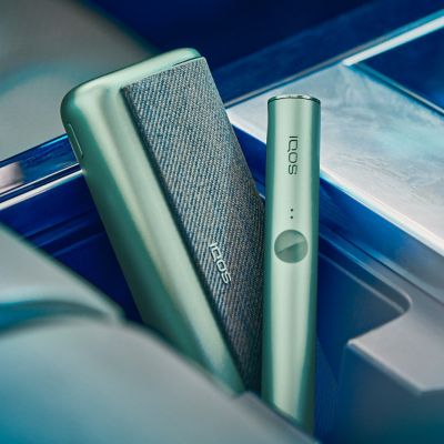 Un cargador de bolsillo y un dispositivo IQOS ILUMA PRIME color Jade Green.